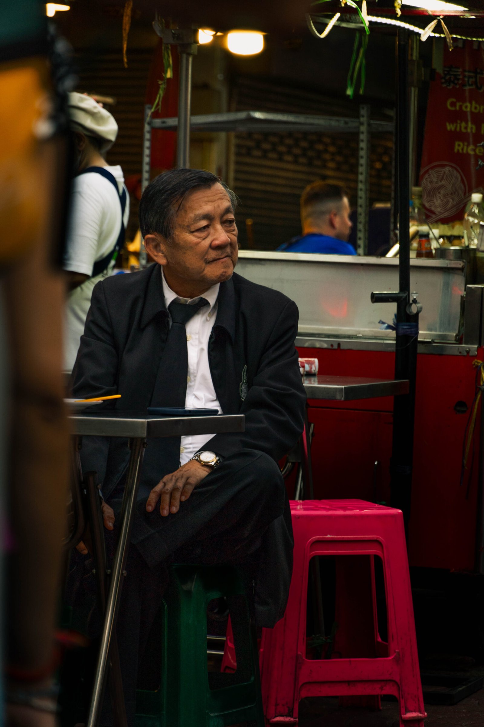 Portret biznesmena w eleganckim garniturze na ulicy Chinatown w Bangkoku – profesjonalne zdjęcie w azjatyckiej scenerii miejskiej