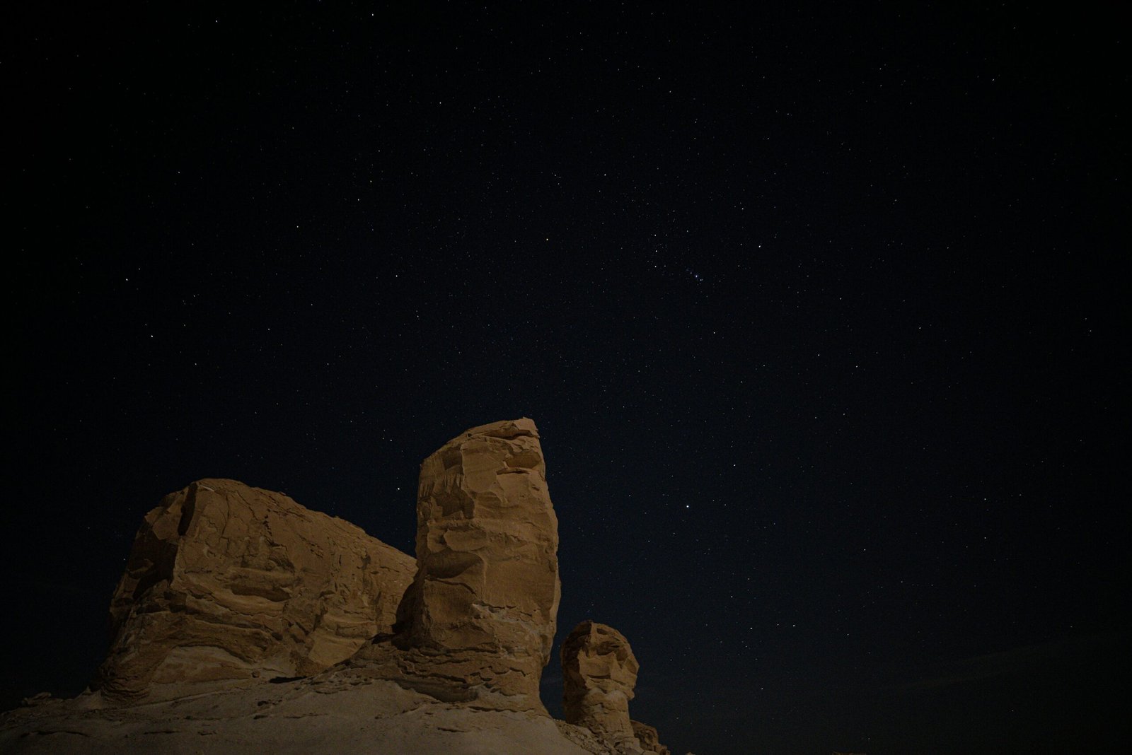 A night view of natural rock formations under a starry sky at Siwa Oasis in Egypt.